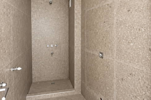 Baño moderno en construcción con azulejos de piedra