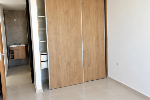 Dormitorio moderno con armario y baño