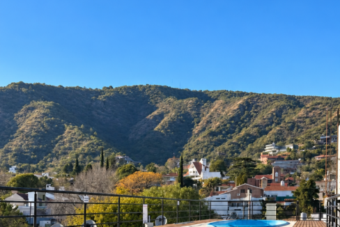 Terraza soleada con piscinas y montañas