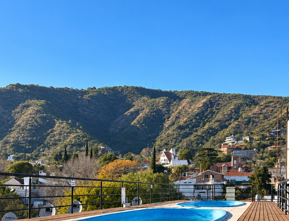Terraza soleada con piscinas y montañas
